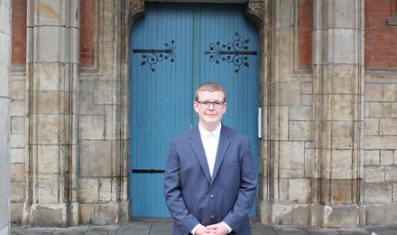 Hansi Tympel steht vor einer hölzernen Tür