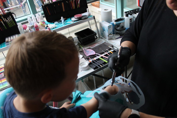 Ein Junge bekommt ein Aibrush Tattoo