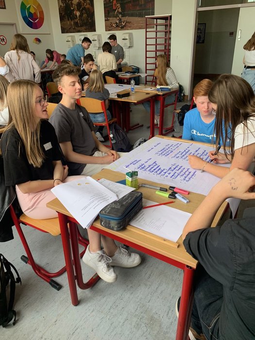 Schülerinnen und Schüler arbeiten in Gruppen und entwerfen Plakate