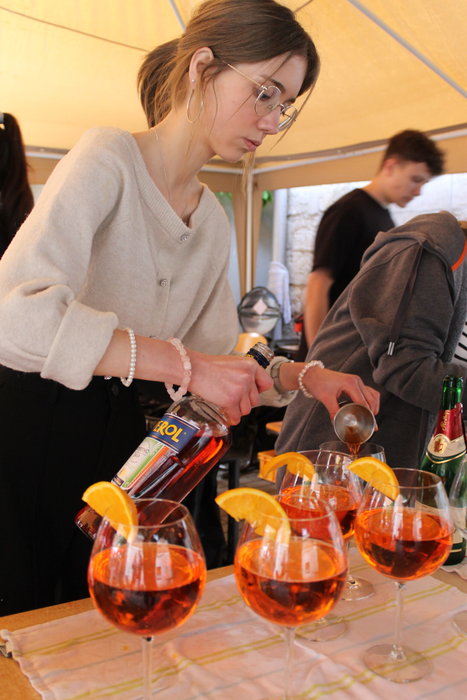 Eine Schülerin mit Brille bereitet Aperol Spritz zu