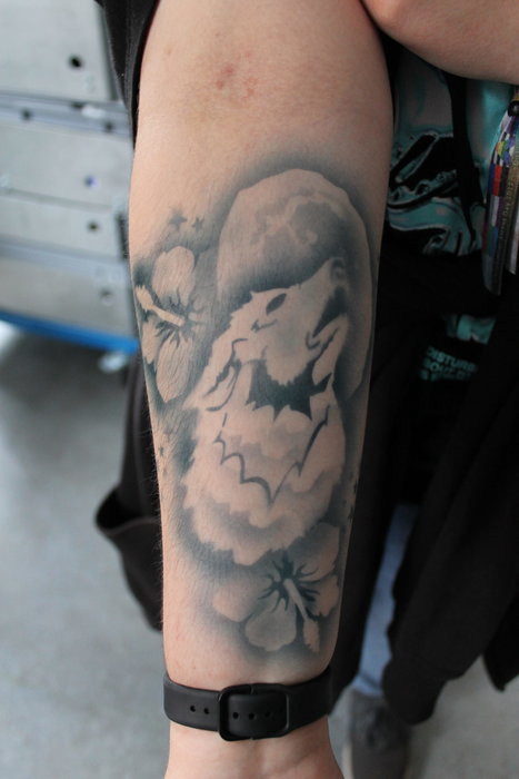 Ein Airbrush-Tattoo mit einem Wolf als Motiv auf einem Unterarm