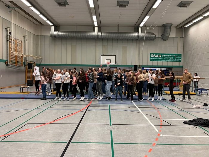 Schülerinnen und Schüler springen in der Turnhalle