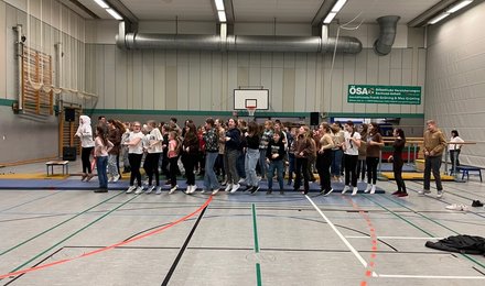 Schülerinnen und Schüler springen in der Turnhalle