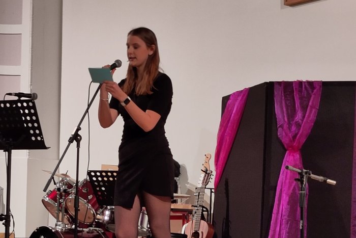 Eine Schülern trägt beim Jahrgangskonzert eine Vortrag vor.