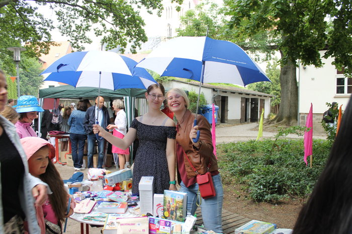 Zwei Frauen halten weiß-blaue Regenschirme in der Hand