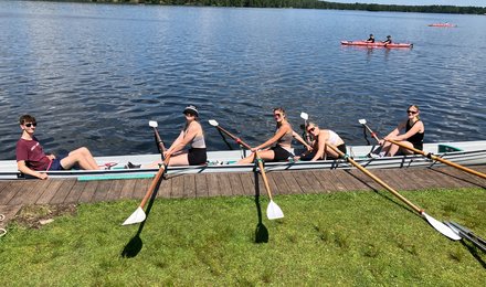 Foto eines Teams des Wasserlagers. Fünf Personen sitzen in einem Kajak