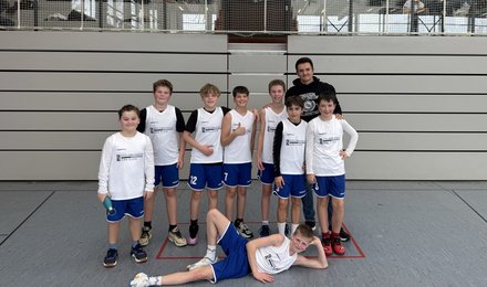 Gruppenfoto des Basketballteams in der Sporthalle.