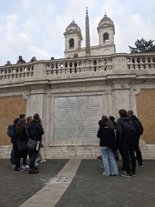 Schülerinnen und Schüler lesen die Tafel an der Trinità dei Monti in Rom